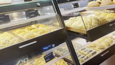 A customer using tongs to pick up freshly golden baked. Stock Footage 328963404