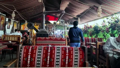 Customer Viewing Traditional Artifacts and Decor Inside a Cultural Cafe in Vídeo Stock 330983202