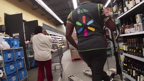 Customer walks through crowded area of workers Walmart Neighborhood Market re Stock Footage 157893083