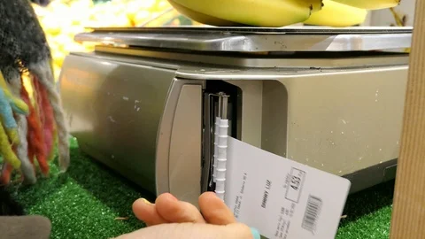 Customer weighs fruit on store scale and takes the label Stock Footage 125159218