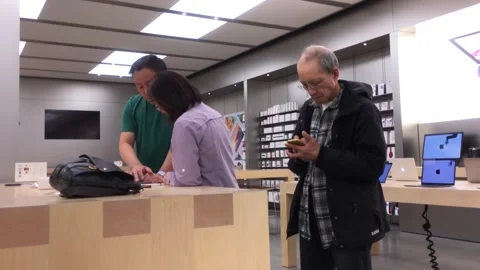 Customers and staff interacting at a tech retail store showroom Video stock 328220552