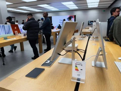 Customers browse sleek Apple computers in a modern tech showroom with brigh.. Stock Photos