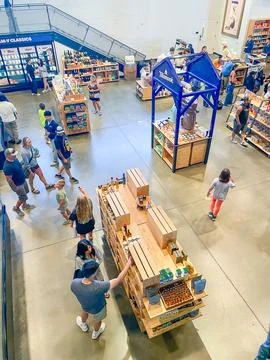 Customers browsing a wooden display table filled with specialty food produc.. Stock-Fotos
