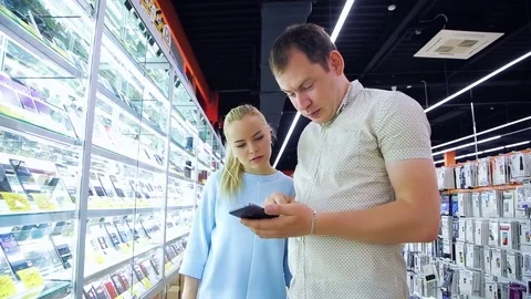 Customers choose products in an electronics store Stock Footage 78182894
