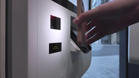 Customer's hand using a smartphone to scan an automated parcel locker displ.. Stock Footage 318831981