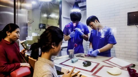 Customers look at the chef making flower candy, Beijing, China Stock-Footage 67489443