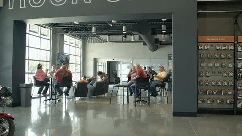 Customers lounging in a motorcycle store waiting room, Full HD Stock Footage