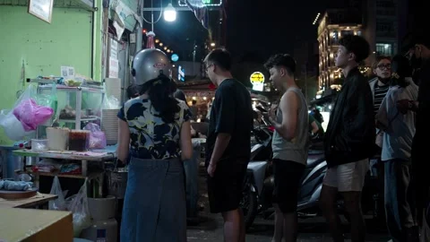 Customers queue at street food stall in District 1, Saigon at night Vídeos de archivo 331287432