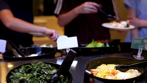 Customers Serving Fresh Greens at Self-Service Salad Bar Stock Footage 323160668