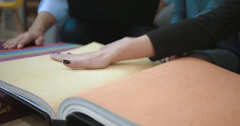 Customers of the store are touching the samples of wallpaper Stock Footage 82858912