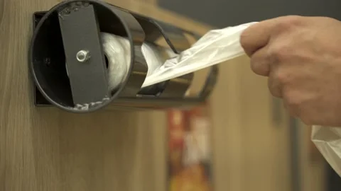 The customers take a disposable plastic bag from a metal dispenser. Stock Footage 131554562