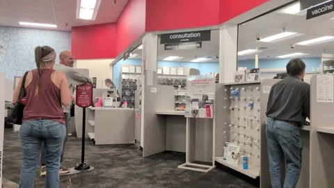 Customers wait in line at a local pharmacy counter inside a retail store Video stock 346314670