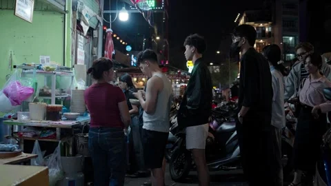 Customers Waiting In Queue At Night, Buying Food From Sidewalk Stall In Vídeos de archivo 331599240