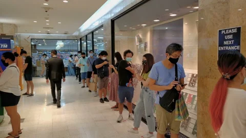 Customers Wearing Face Masks Lined up To Enter Store During Coronavirus Pandemic Stock Footage 130564302