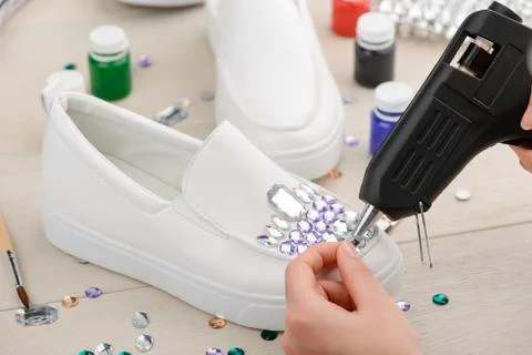 Customization of shoes with rhinestones using a hot glue gun Stock Photos