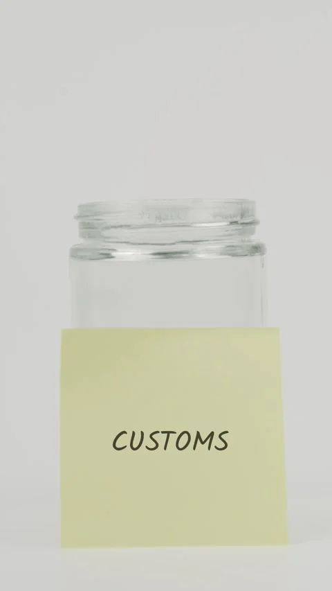 Customs text or word on yellow sticky note attached to glass jar with hand Stock Footage 311706992