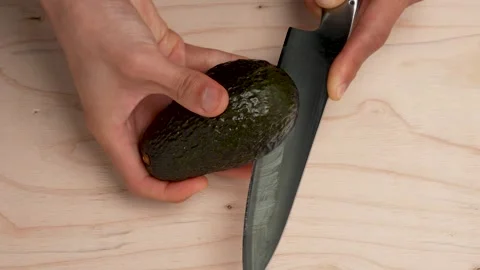 Cut the avocado in half. Stock Footage 320379762