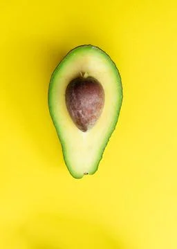 Cut avocado on a yellow background. Selective focus. Stock Photos