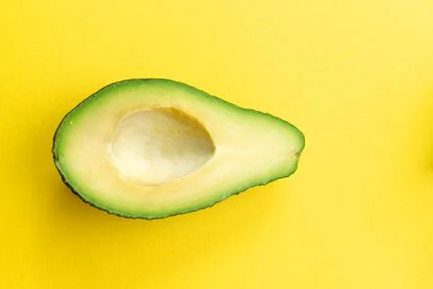 Cut avocado on a yellow background. Selective focus. Stock Photos