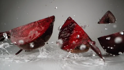 Cut beet falling on water surface. Slow Motion. Stock Footage 128771685
