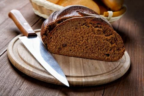 The cut black bread on a wooden table Stock Photos