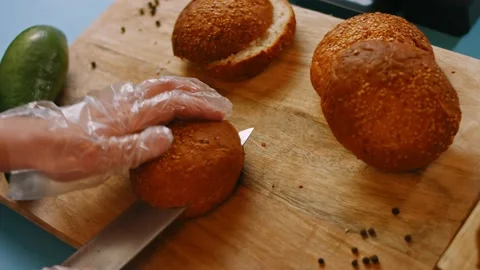 Cut the bread for the burger. Prepare Smoked Salmon Bagel. 4k video Stock Footage 164399218