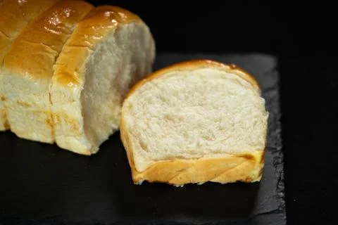 Cut bread, loaf on the black background. Copy space. Bakery concept Stock Photos