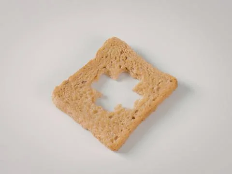 Cut bread slice with heart-shaped hole Stock Photos