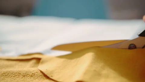 Cut the bright yellow fabric with scissors, close-up. Video stock 142990466