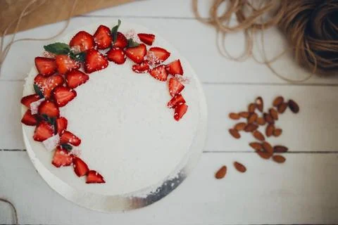 Cut the cake. Cake under the curd cream under strawberry. Stock Photos