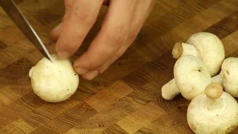 Cut champignons with a sharp knife on a wooden board Stock Footage 83374087