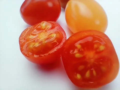 Cut cherry tomatoes close up isolated on white Stock Photos