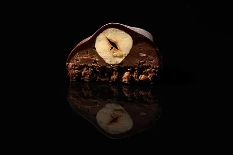 Cut chocolate candy with nut inside on black background Stock Photos