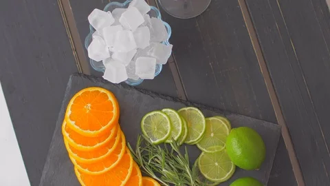 Cut into circles of lime and orange on black stone. Preparation for cocktails Stock Footage 110026060