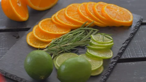 Cut into circles of lime and orange on black stone. Preparation for cocktails Video stock 110034804