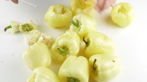 Cut the core from the peppers.The knife cleans vegetables on the kitchen table. Stock-Footage 137075546