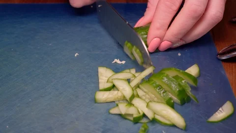 Cut the cucumber on green background Stock Footage 125321615