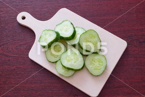 Cut cucumber on a wooden cutting board. Step by step cooking Stock Photos