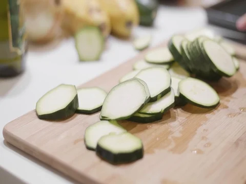 Cut up cucumbers on a cutting board in slow motion Stock Footage