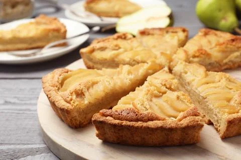 Cut delicious sweet pear tart on wooden table, closeup Stock Photos