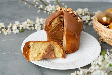 Cut Easter cake on plate decorated with spring flower branches Stock Photos