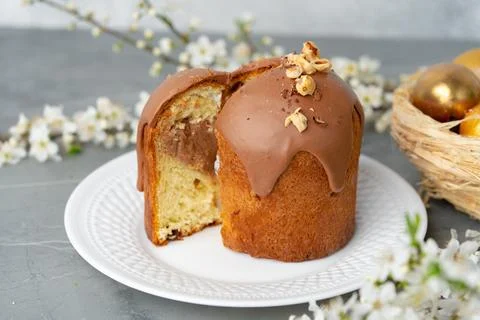 Cut Easter cake on plate decorated with spring flower branches Stock Photos