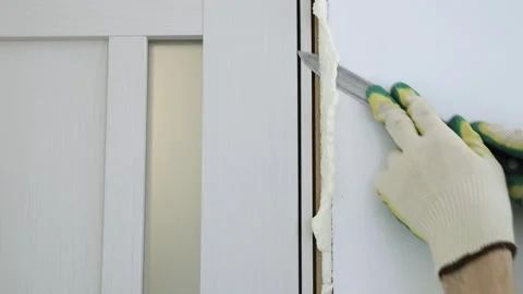 Cut off excess hardened polyurethane foam with a knife Stock Footage 255039227