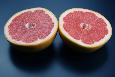 Cut grapefruit on a dark background Stock Photos