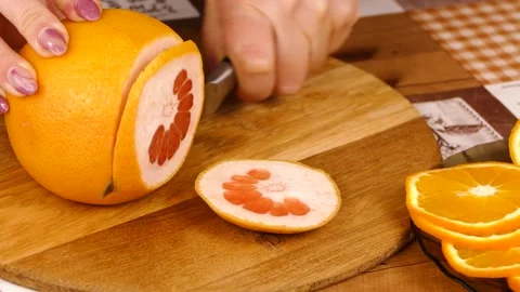 Cut An grapefruit Into a lot Slices on a plank Stock Footage 233620666