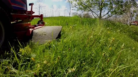 Cut grass blown out the discharge chute of a riding mower Stock Footage 63178912