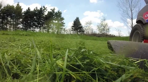 Cut grass blown out the discharge chute of a riding mower Stock Footage 63178983