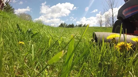 Cut grass blown out the discharge chute of a riding mower Stock Footage 63179002
