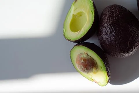Cut green avocado lying on the table top view Stock Photos