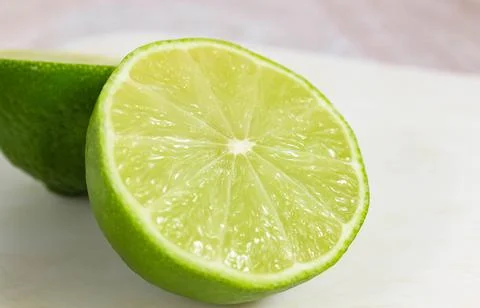 Cut off half of a green lime on a light background. Stock Photos